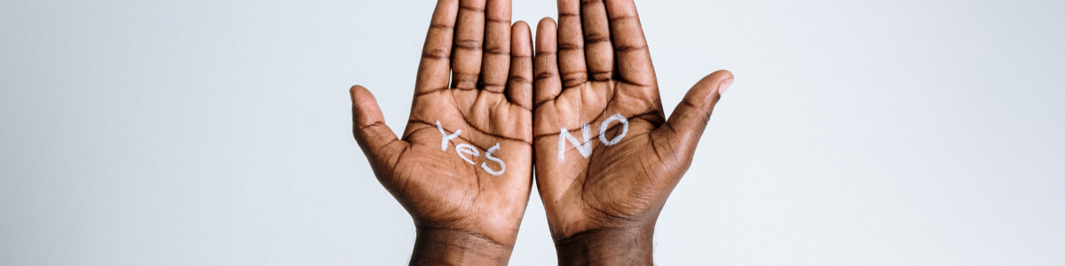 A photo of two hands, one that has yes written on it, the other with no. Demonstrating symbolically the choices given in abstinence-only models.