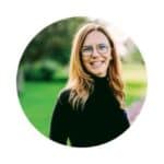 Catherine is wearing a black top, glasses, and smiling